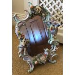 Continental porcelain toilet mirror with putti. a/f 36 h x 28cms w.