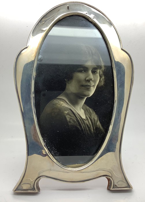A silver photograph frame, Birmingham 1922, slight dint to top with oak back and stand. 19.5cms h.