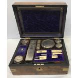 A brass bound walnut ladies vanity box with brass escutcheon and carrying handle, well fitted