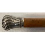 A silver topped cane, 89cms, 1 mark rubbed, London late 19thC crest to top.