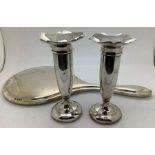 Two silver vases, 12cms h, creases to top of one, weighted bases with a silver backed dressing table