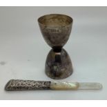 A silver spirit measuring cup, 39gms, London 1904 with a silver and mother of pearl bookmark a/f.