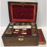 A 19thC mahogany ladies vanity box with mother of pearl escutcheon and oval to top, well fitted with