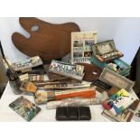 A quantity of vintage artists materials including two wooden pallets, paints, paint tins, books,