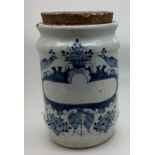 An 18thC Delft dry drug jar with cork stopper, peacocks flanking a basket of fruit with