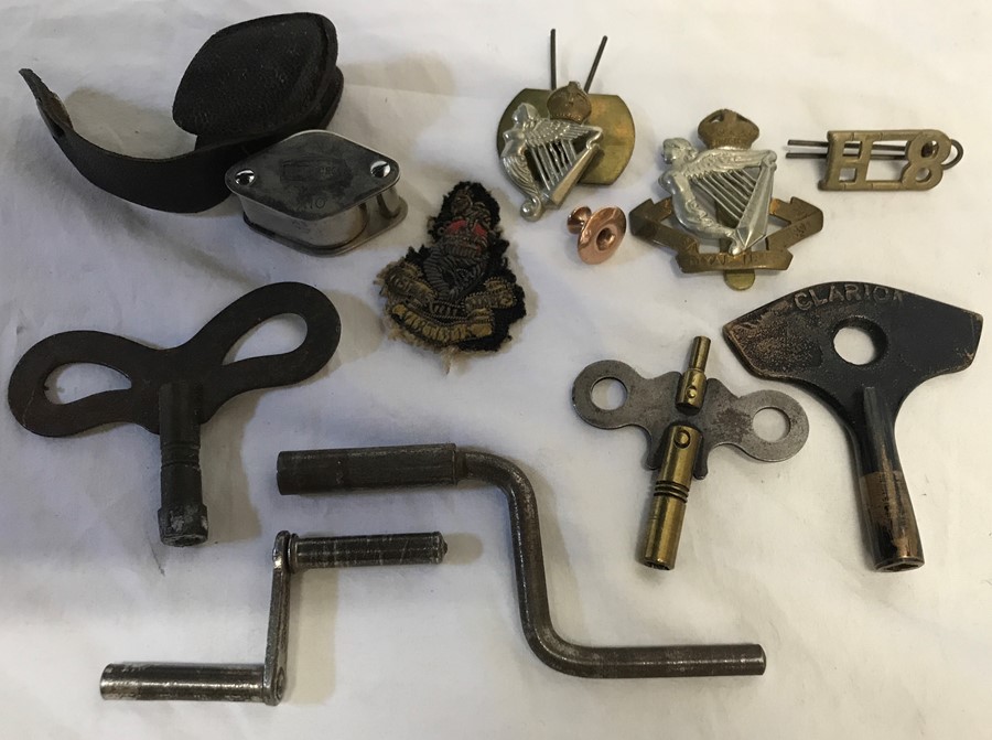 Military cap badges, Kings Royal Irish, assorted clock winding keys, eyeglass and a 9ct gold