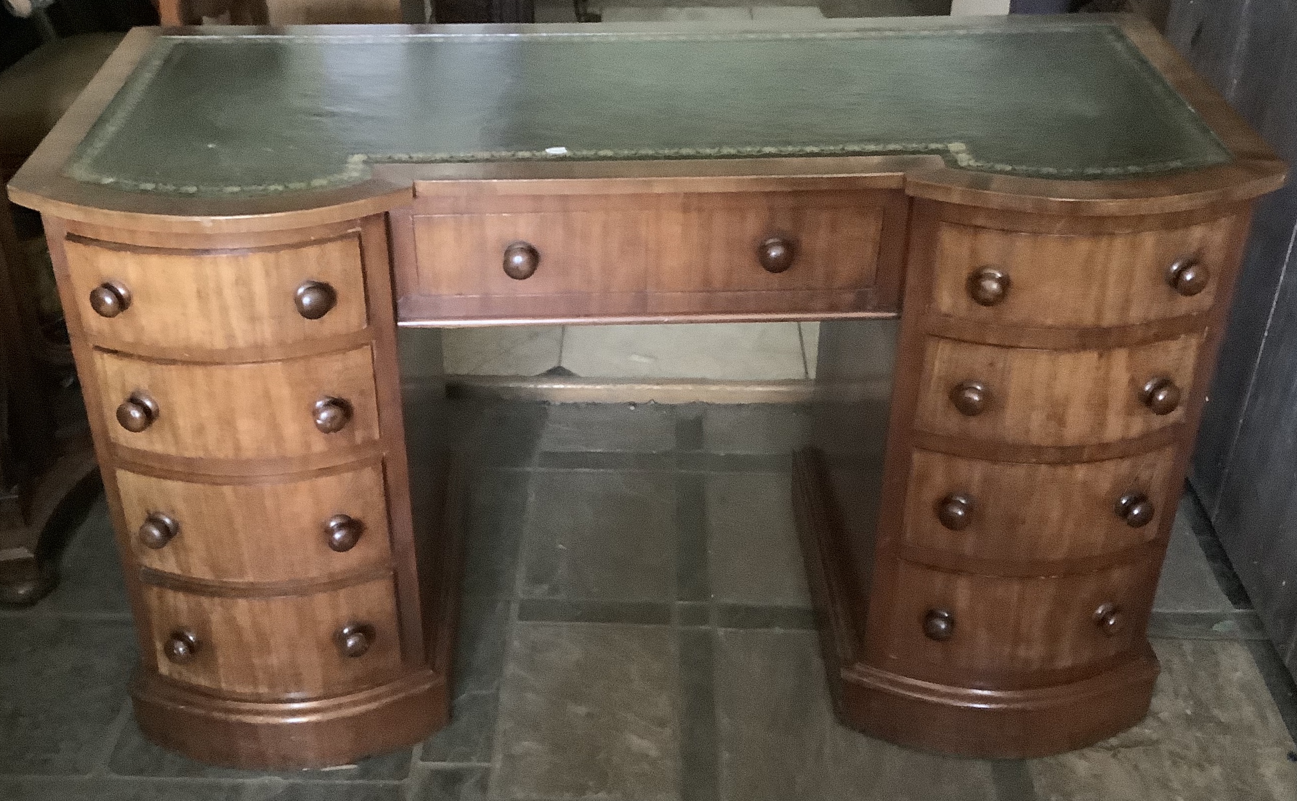 A 19thC mahogany kneehole desk with a shaped front, tooled green leather top. 126cms w.