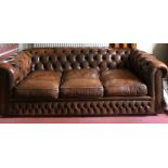 A brown leather upholstered button backed sofa. 214 w x 89 d x 81cms h.