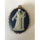 A Wedgwood cameo of a classical female playing harp in a yellow metal surround marked 9ct. 7.5 x