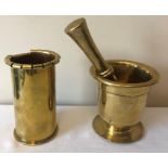 A 19thC brass pestle and mortar with a shell case. 16.5cms l.