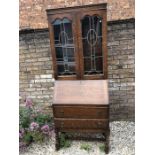 An oak bureau bookcase with glazed leaded top, base with 2 drawers and barley twist legs. 182 h x 72