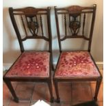 A pair of Edwardian rosewood and inlaid chairs.