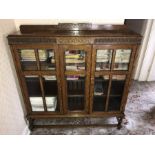 An oak 2 door glazed bookcase. 120 w x 26 d x 129cms h.