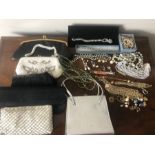 A quantity of vintage costume jewellery and evening bags.