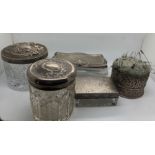 Three various glass and silver topped jars, one glass jar with plated top and a pin cushion with