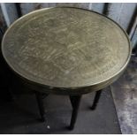 An early 20thC brass topped table on folding base. 60cms d.