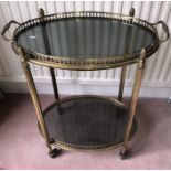 A vintage 2 tier brass trolley, lift off oval tray to top. 53 x 34cms x 65ms h.