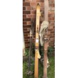 Two pairs of vintage skis and poles together with badminton rackets.