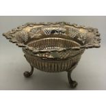 A silver bowl raised on 3 legs with scrolled feet. Reeded and pierced body. London 1927, 237.7gms.