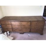 A 19thC pine 9 drawer unit on bracket feet and brass swan neck handles. 86 h x 233 w x 67cms d.