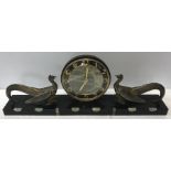 A French Art Deco mantle clock on a black marble onyx base with gilt metal confronting peacocks.