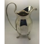 A silver cream jug of octagonal form on 3 feet, Birmingham 1925. 127.1gms.