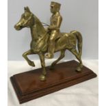 Brass figure, military officer mounted on a Horse, on a wood base stand. Approx 22 h x 23cms w of