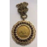 An 1894 gold sovereign mounted in a 9 carat gold mount with a ring of garnets and chain. 23gms total