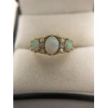 A three stone opal and diamond ring, opals separated by 2 lines of 3 diamonds. 4.1gms. Size Q.