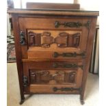 An early 20thC mahogany two door cabinet in Arts and Crafts style embossed strapwork to doors on