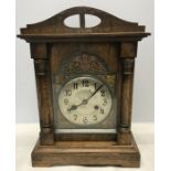 Oak cased mantle clock with key and pendulum. Brass cherub decoration around dial. 37cms h x 26cms w