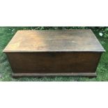 A 19thC stained pine blanket box with metal carrying handles to the sides. The hinged lid opening to