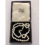 A string of cultured pearls with a decorative clasp marked 14K. 47cms l.