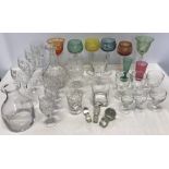 Good quality drinking glassware including cut coloured glasses, 2 decanters, 1 bearing engraving