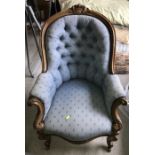 A 19thC mahogany framed armchair on cabriole legs and brass castors upholstered in blue.