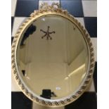 An oval white and gilt bevel edged wall mirror. 60 x 45cms.