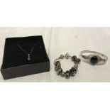 Pandora bracelet with ten bead charms stamped 925, a silver and gold pendant set with purple stone
