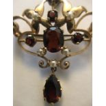 A 9 carat gold brooch/pendant set with seed pearls and red stones. 6.7gms total. 5cms l.