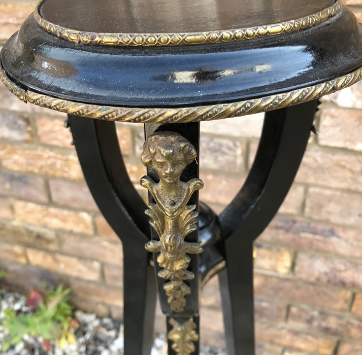 Black painted plant stand with decorative brass fittings, 90cms h. Condition ReportSplit to middle