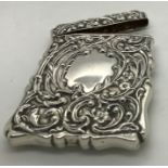 A silver card case marked Walker and Hall, repousse decorated with foliate scrolls, vacant