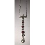 An Edwardian diamond, ruby and pearl pendant on white metal chain. Pendant 5cms l. 5.2gms.