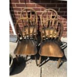 Four Ercol dining chairs.