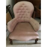 A Victorian cabriole legged nursing chair on castors, upholstered in pink velvet.