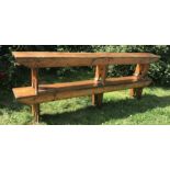 Two stained pine school benches with trestle supports. 244 l x 27 d x 45cms h.