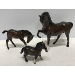 Royal Doulton brown horse and foal, horse 19.5cms h, foal 11cms h together with a Beswick Highland