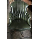 Green leather button backed swivel desk chair on wood base. Height to seat 47cms. Height to back