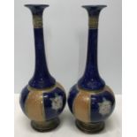 Pair of Royal Doulton stoneware slim neck vases, blue ground with tubeline floral decoration, 29cms.
