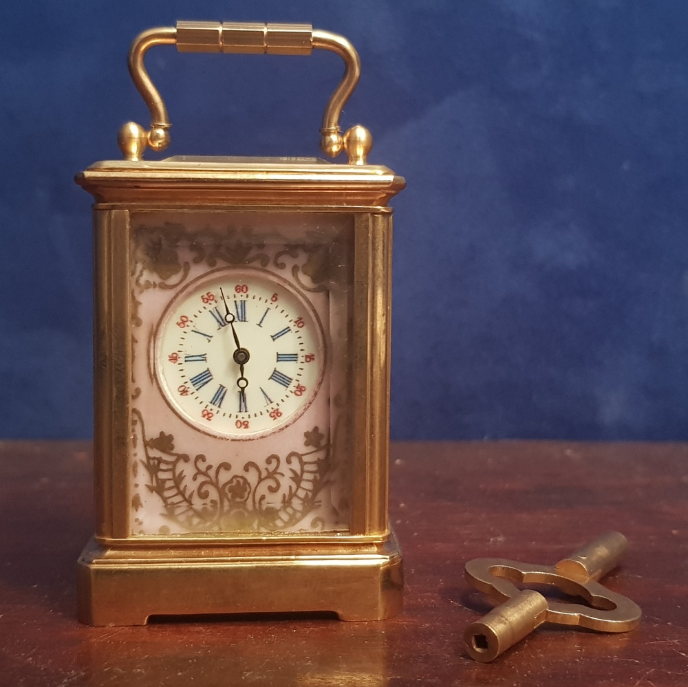 A MINIATURE BRACKET CLOCK, with picture panels and bevelled glass, key with the clock