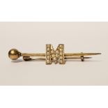 AN ANTIQUE 15CT BAR BROOCH SET WITH SEED PEARLS IN THE FORM OF THE LETTER 'M'