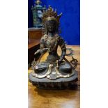 A BRONZE & POLISHED BRASS STATUE OF A SEATED HINDU DIETY, with inset stones, 12" tall approx